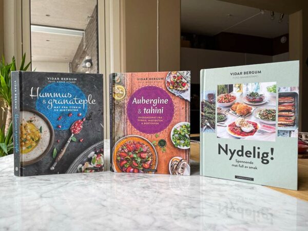 Bøkene Hummus & granateple, Aubergine & tahini og Nydelig! stående på bord