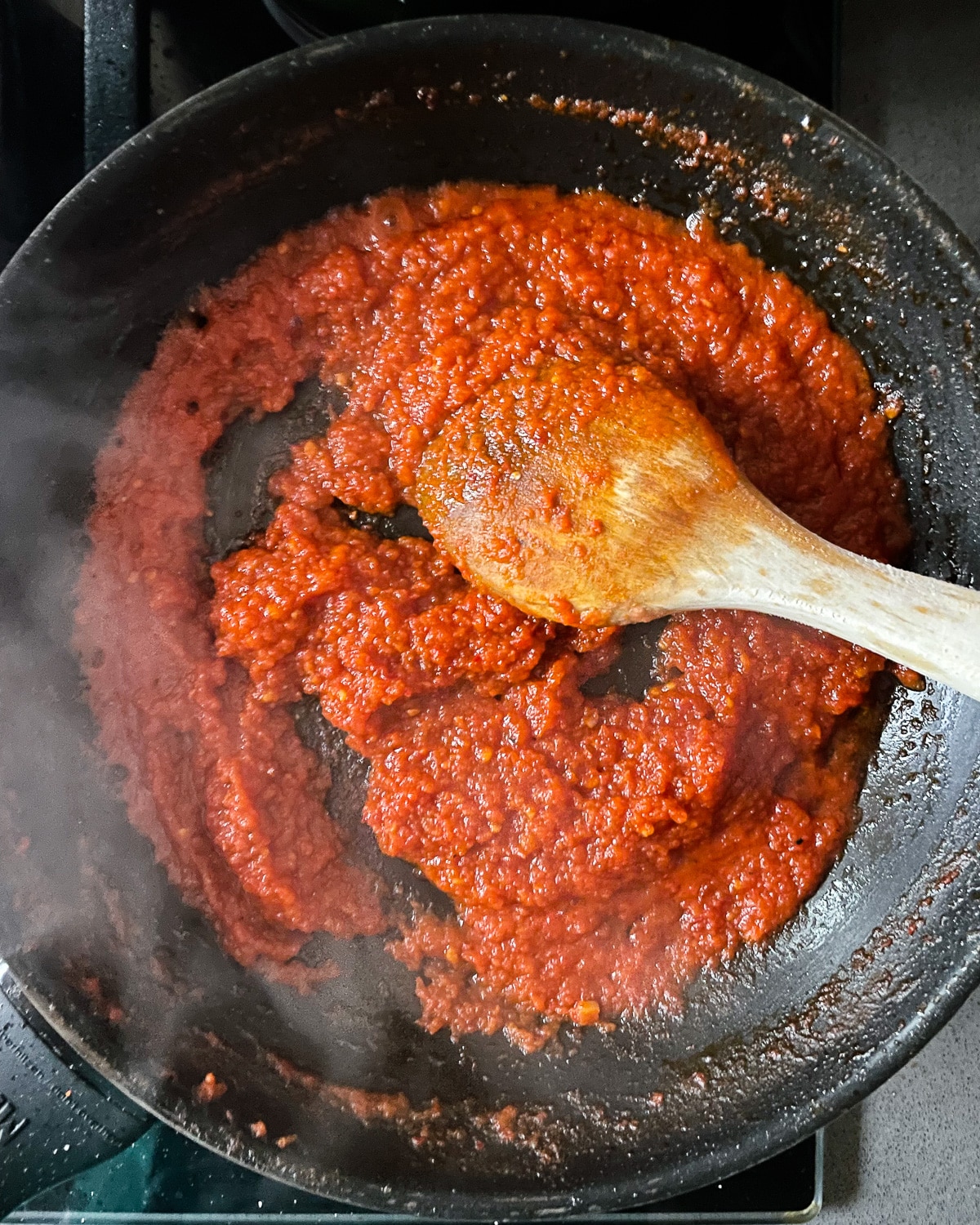 tykk tomatsaus basert på tomatpuré stekes i panne